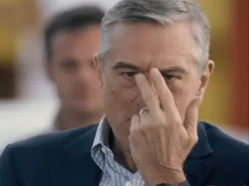 The image features a man with gray hair wearing a suit, holding his hand up to his face as if he's making a funny or strange facial expression. The caption of the image reads "$DOG Army sees you". This suggests that the man is intentionally making an odd or humorous gesture for the camera, possibly to entertain or amuse viewers.

The background of the image shows another person partially visible behind the main subject.