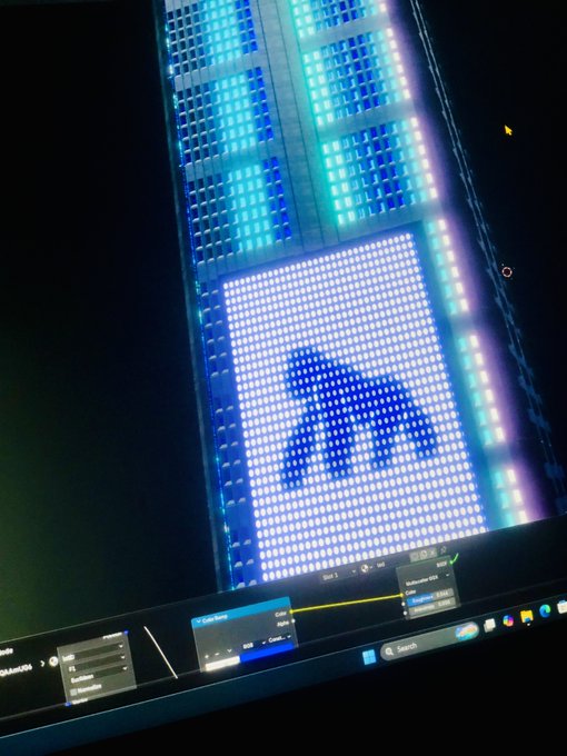 A computer monitor displays a colorful LED-style image featuring bright blue and purple pixelated patterns, with editing software panels visible along the bottom.
