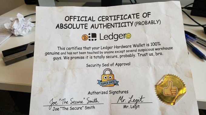 A humorous fake certificate from 'Ledger' titled 'OFFICIAL CERTIFICATE OF ABSOLUTE AUTHENTICITY (PROBABLY)', signed by 'Joe The Secure Smith' and 'Mr. Legit' with a 'Super Safe' lock badge.
