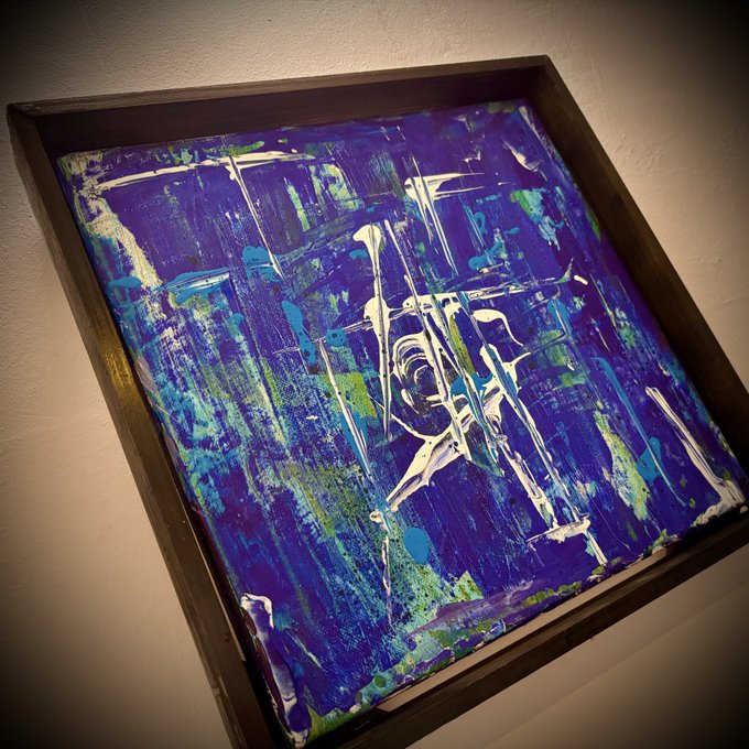 A framed abstract painting featuring thick, textured brushstrokes in shades of blue, green, and white, displayed on a wall.