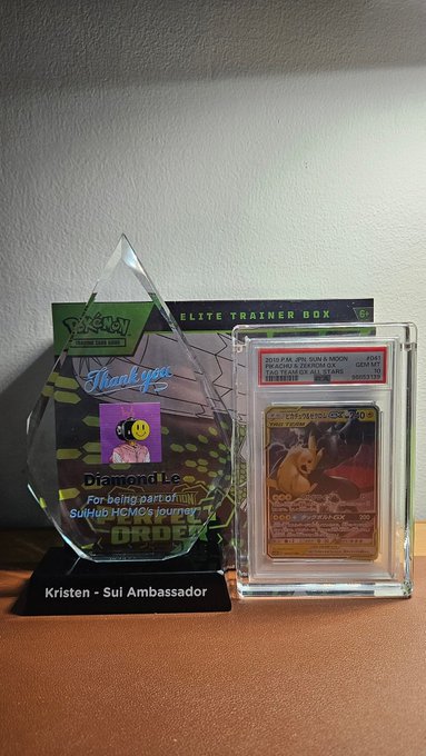 The image shows two Pokemon cards displayed next to each other, with a glass trophy case containing another card behind them. The text "Real question for the @SuiCommunity" suggests that there might be an ongoing discussion or debate about the value of these items in the Pokemon trading community. The post also mentions that the collector market is massive and that @SuiNetwork offers speed and low fees, which could potentially impact the trading ecosystem.