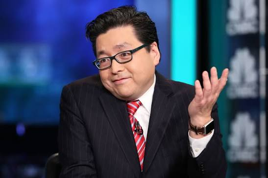 A man with glasses in a pinstripe suit and red tie gesturing during what appears to be a televised interview or news segment.