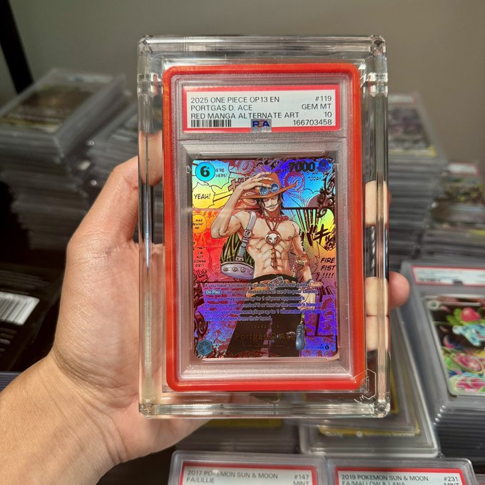 Hand holding a PSA GEM MT 10 graded 2025 One Piece OP13 EN Portgas D. Ace Alternate Art trading card, with stacks of other graded cards visible in the background.