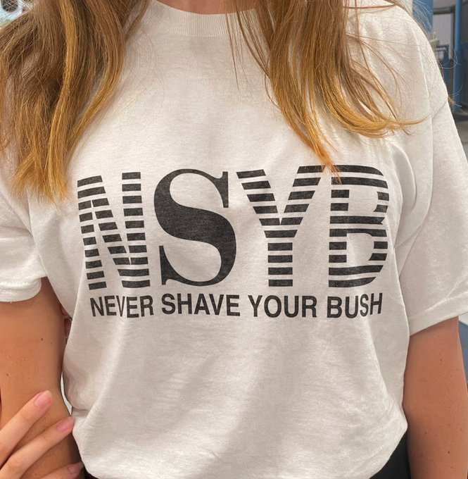 Person wearing a white t-shirt with bold black text reading 'NSYB - NEVER SHAVE YOUR BUSH'.