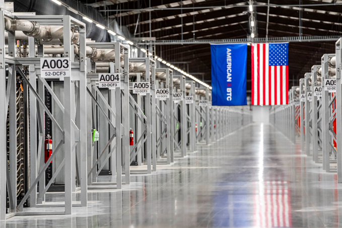 The image shows a large warehouse with rows of metal racks, likely used for storing goods or equipment. A blue American flag is hanging from one of the racks, adding a patriotic touch to the industrial setting. The caption "Vega today. More Bitcoin tomorrow." suggests that there might be an event related to Bitcoin happening in the area soon.