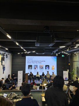 A conference panel session takes place in a modern venue, with speakers seated at a long table and a presentation screen behind them reading 'Webinar: KIMA's Movements Could Be Closer Than You Think.'