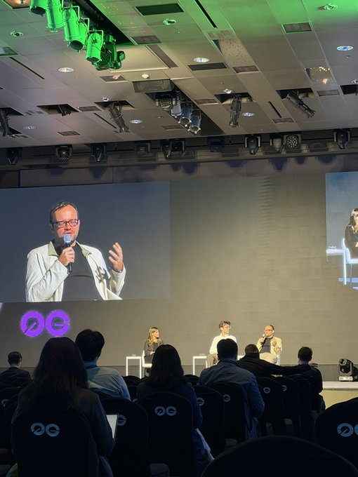 A panel discussion is taking place at an OG event, with a speaker shown on a large screen holding a microphone, while three panelists sit on stage addressing an audience seated in chairs marked with the "OG" logo.

The image shows a conference setting that suggests a learning or professional development atmosphere, though the post's reference to "a very bad day" followed by "encouraging" hints that the speaker's message or the event itself provided a positive uplift after a difficult previous experience.