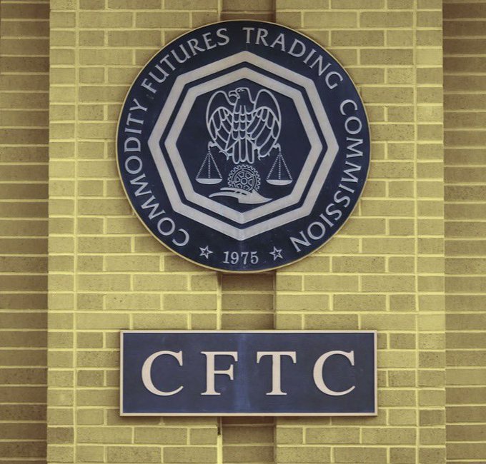 The official seal of the Commodity Futures Trading Commission (CFTC), established in 1975, is mounted on a tan brick wall above a sign displaying the agency's acronym.