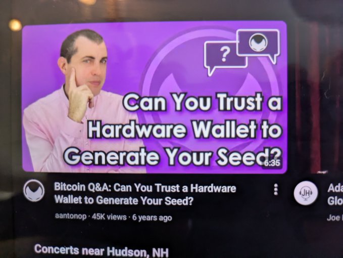 A YouTube video thumbnail by 'aantonop' titled 'Bitcoin Q&A: Can You Trust a Hardware Wallet to Generate Your Seed?' features a man in a pink shirt with his hand on his chin.