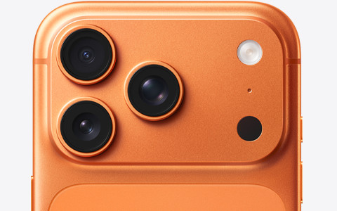 A close-up of the rear camera module of an orange smartphone, likely an iPhone 17 Pro or Pro Max in its Cosmic Orange finish, showcasing its triple-lens camera system and flash. The image aligns with the post's recommendation for more orange-colored products, highlighting the visually warm and eye-catching tone of the device.
