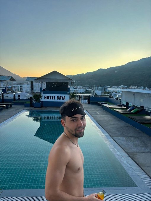 A shirtless man wearing a "ZZZ" sleep mask stands poolside at Hotel Baya during a scenic sunrise over the mountains. The "GOOD MORNING" caption pairs with the image as he jokingly wears the sleep mask upside down while awake, seemingly asking for $SOL addresses on Solana.