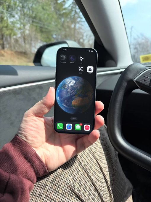 The image shows a person holding up their cell phone, which displays an Earth map with a planet visible. The person appears to be wearing a brown sweater or jacket while using the phone. The caption provided suggests that they are discussing cryptocurrency cards, specifically the Avici Money and KAST XYZ cards.