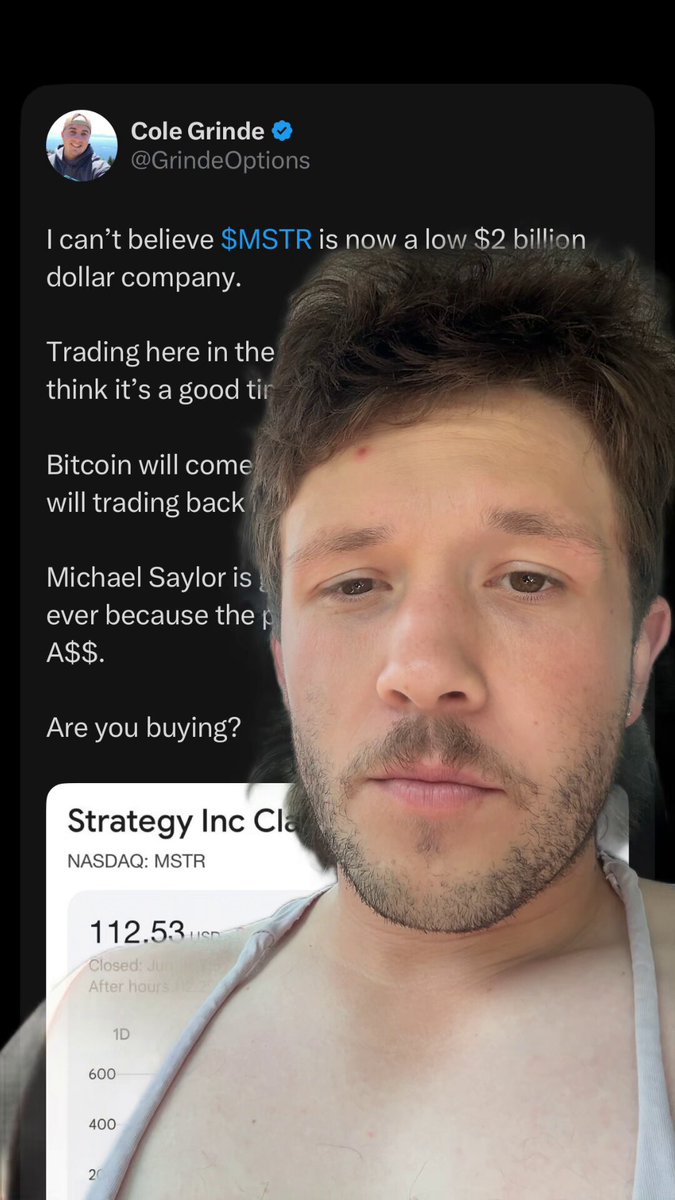 The image features a man with a beard wearing white clothes, who is making a funny face for the camera while holding up a cell phone screen displaying information about Bitcoin. The text displayed on his cellphone says "I can't believe MSTR is now a low $2 Billion company. Trading here in the ... think its a good idea".