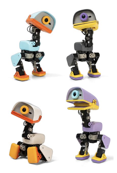 Four small colorful robots with googly eyes are displayed in different poses and color schemes including blue/orange, gray/yellow, white/orange, and purple/yellow.