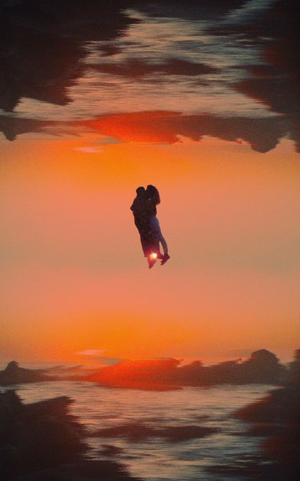 A silhouette of a couple embracing appears to float against a vibrant orange sunset, framed by mirrored, dreamlike reflections of clouds and water that create a surreal, otherworldly atmosphere. The ethereal, warm-toned scene complements the post's "Gm" greeting, evoking a serene, romantic morning vibe perfect for a "Snooze" moment.