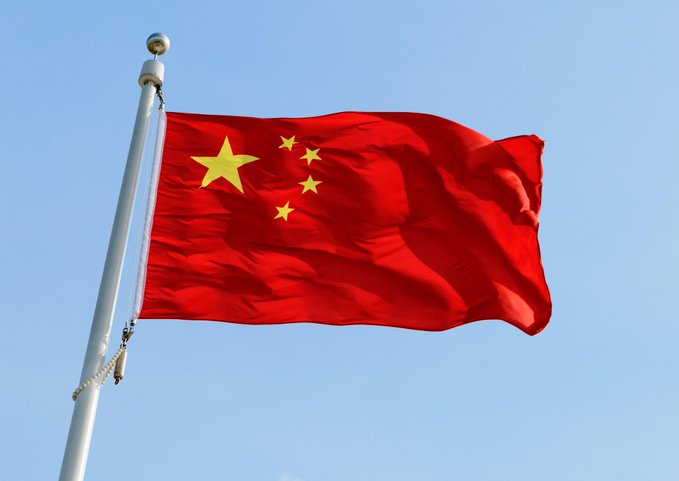 The flag of China waves against a clear blue sky, symbolizing the country where Zhibao Technology ($ZBAO) is based as it announces a $154.7 million Bitcoin-funded private placement of 2,380 BTC with non-U.S. investors.