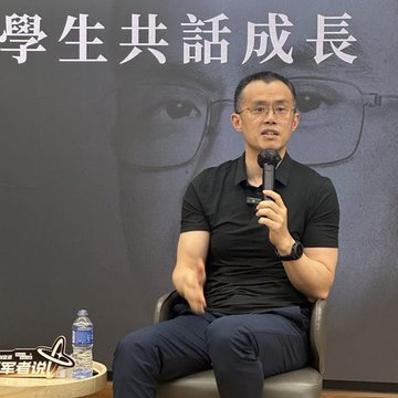 A man in a black polo shirt speaking into a microphone at an event, with Chinese text '學生共話成長' and '華菁分享' visible on banners in the background.