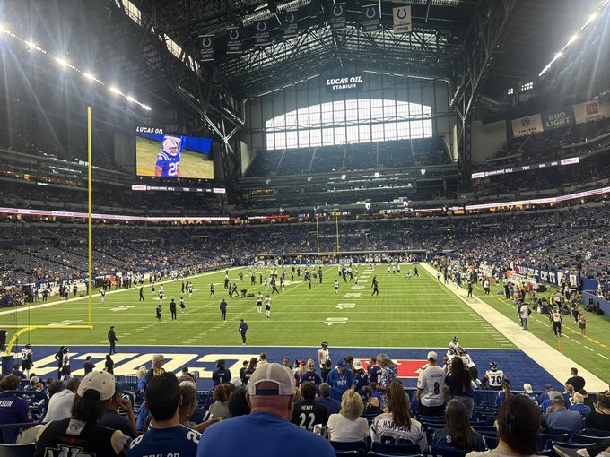 An interior view of Lucas Oil Stadium during an American football match, with players on the field and a large crowd in the stands.