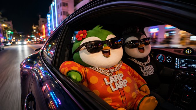 Two cartoon bird characters wearing sunglasses and 'LARP LARP' orange shirts ride in a car at night through a neon-lit city street.