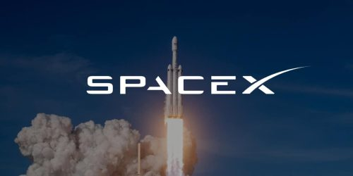 A SpaceX Falcon Heavy rocket lifts off against a blue sky, with the 'SPACEX' logo overlaid in white text.