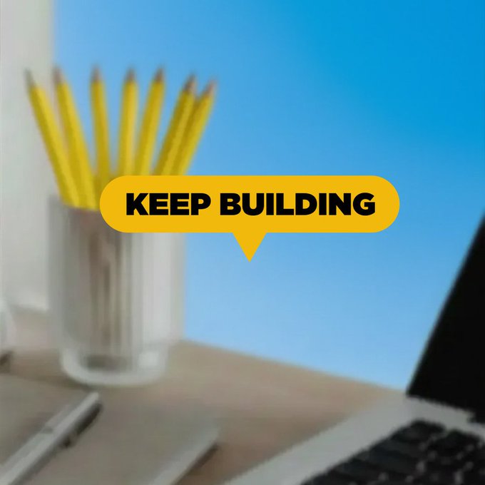A blurry desk scene features a glass holding yellow pencils next to a laptop, with a bold yellow speech bubble overlay reading "KEEP BUILDING" — a motivational nudge encouraging continued productivity over the weekend.
