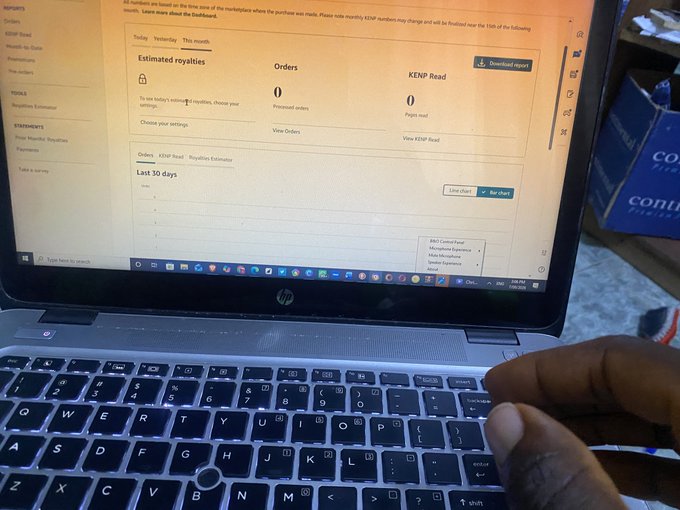 A person's hand rests on the keyboard of an open HP laptop displaying an Amazon KDP (Kindle Direct Publishing) dashboard with 'Estimated royalties', 'Orders', and 'KENP Read' all showing zero.