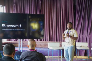 A speaker presents on stage at a conference, with a screen behind him displaying "Ethereum" alongside the message "From world computer to settlement layer," reflecting the panel's discussion on the maturing Web3 industry, including topics like AI, stablecoins, and privacy that were highlighted during Canada Crypto Week.