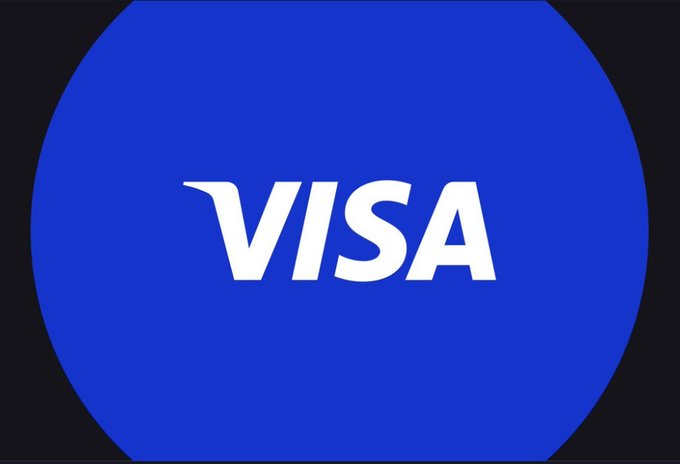 The image features a blue circle with the word "Visa" written in white letters, which is located at the center of the frame. The background of the image is black, making the blue circle stand out prominently. Below the circle, there's some text that reads "Visa just announced to launch crypto credit cards in more than 100+ countries". This information suggests that Visa has recently made a significant announcement regarding their new crypto credit card offerings.