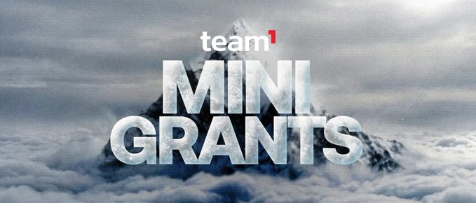 The image features a dramatic mountain peak emerging above a sea of clouds, overlaid with the text "team1" and bold, frosted-style lettering reading "MINI GRANTS." This visually striking backdrop symbolizes the elevated opportunities and reach of Team1's Mini Grants program, which offers up to $10,000 in fast funding for early-stage builders, developers, and community initiatives on the Avalanche ecosystem—aligning with the post's call to support projects that move the ecosystem forward without a waitlist.