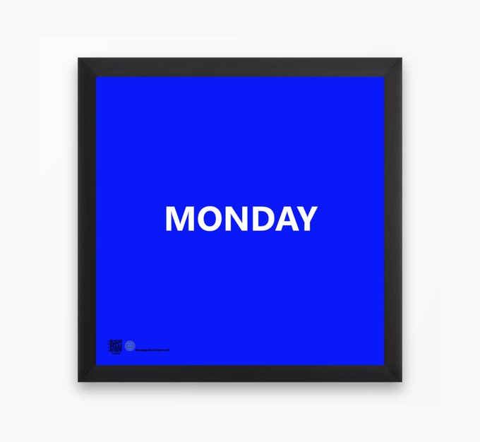 A blue framed poster with white text reading 'MONDAY' displayed against a white wall background.