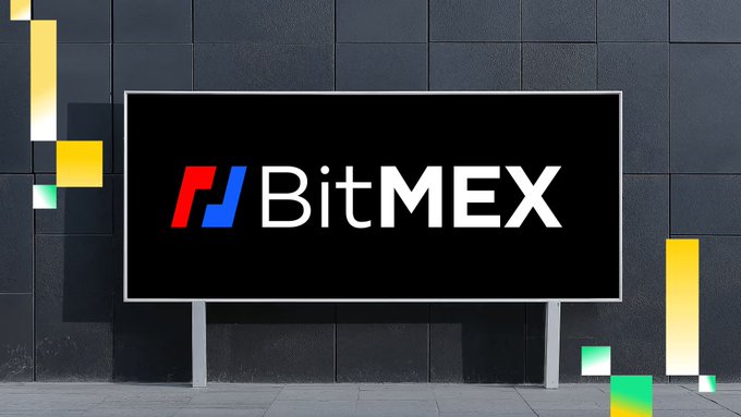 The image shows a large billboard displaying the BitMEX logo, featuring a stylized red and blue "P" icon next to the white "BitMEX" text on a black background, set against a dark tiled wall with colorful geometric accents. This visual relates to the post by highlighting BitMEX as one of the centralized exchanges potentially affected by the recent downturn in crypto trading volumes.
