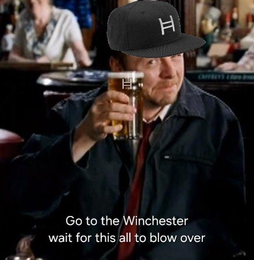 A man in a dark jacket holding up a pint of beer with a superimposed black baseball cap featuring a white 'H' logo, with the caption 'Go to the Winchester wait for this all to blow over'.