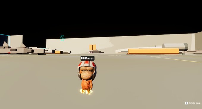 A screenshot from a 3D game or virtual environment showing an ape character wearing a white and red racing helmet labeled 'FFRacer', standing on a flat beige surface with minimal gray structures in the distance and a 'Koda Cam' watermark.