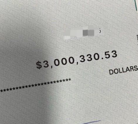 A close-up of a check or financial document displaying the amount '$3,000,330.53 DOLLARS' with personal information redacted.