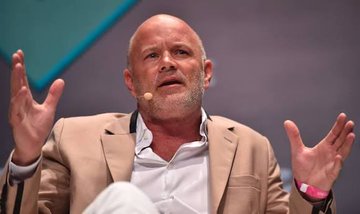 The image shows a bald man wearing a tan suit jacket with his arms raised up in the air. The caption of the photo reads "JUST IN: CLARITY ACT ENTERES MAKE-OR-BREAK PHASE IN JUNE, SAYS GALAXY DIGITAL CEO!". This suggests that there is an important announcement or event related to clarity and transparency taking place in June, possibly involving a company named "GALAXY DIGITAL". The man's raised arms indicate excitement or enthusiasm about the upcoming event.