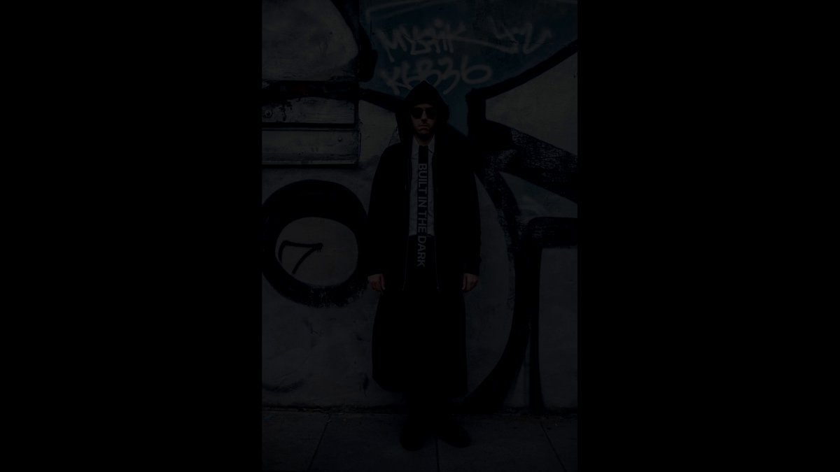 The image features a man standing against a wall with graffiti, wearing a suit and tie. He has sunglasses on his head and appears to be posing for the photo. The caption of the image includes the words "Who says we have zero fashion?" which is likely a reference to the post by @ Berlin Blockspäti.