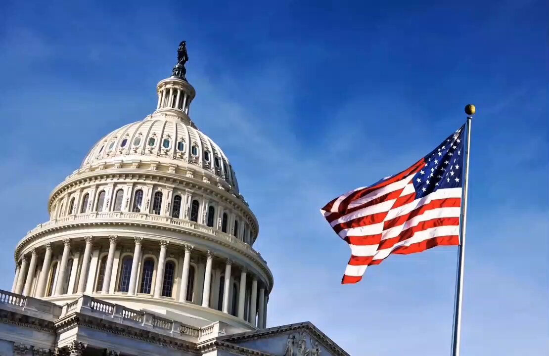 The image features a large white building with an American flag flying above it against a blue sky. The scene also includes a description of seven tax bills being introduced by House Republicans regarding digital assets, stablecoins, and staking.
