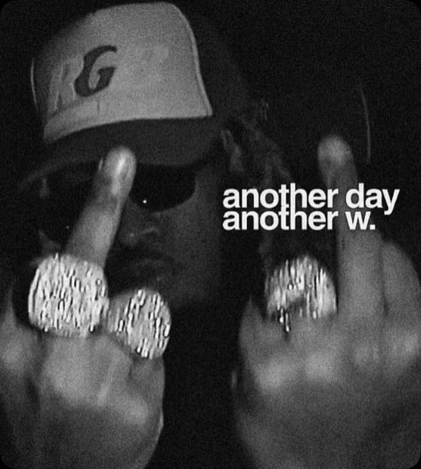 Black and white photo of a man wearing a baseball cap and sunglasses, displaying multiple large diamond-encrusted rings on both hands with raised middle fingers. Text overlay reads 'another day another w.'