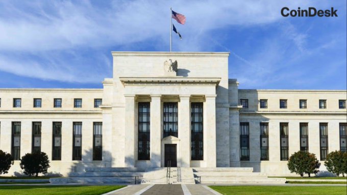 The image shows the Federal Reserve Building (Eccles Building) in Washington, D.C., featuring its iconic neoclassical marble façade with tall columns, the U.S. flag, and an eagle sculpture, accompanied by the "CoinDesk" watermark in the upper right corner. The image ties to the post by visually evoking U.S. financial regulatory authority, complementing the message about Chainlink's engagement with the CFTC in advancing regulatory clarity for digital assets.
