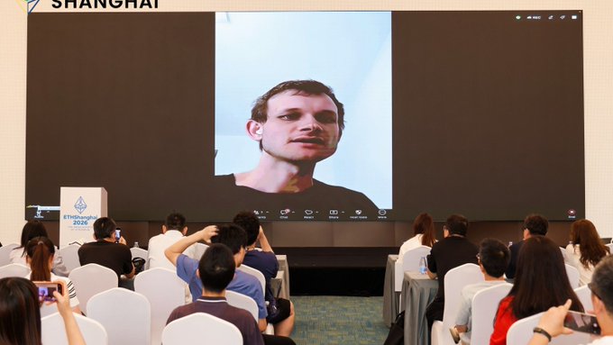 An audience seated at the Ethereum Community Conference (EthShanghai 2024), watching a video presentation on a large screen featuring a man speaking.