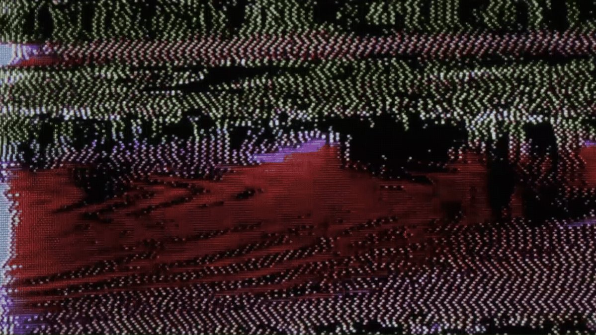 The image shows a close-up of an abstract painting with a red, black, and white color scheme. The painting features a zigzag pattern that appears to be made up of small dots or lines. The background of the painting is a solid gray color, which contrasts with the vibrant colors in the foreground. The text "still available on primary objkt.com/tokens/KT1B56X" suggests that this artwork may be part of an online collection or gallery and can be viewed by anyone with access to the website.