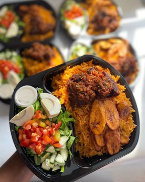 Several black takeout containers filled with Middle Eastern-style food including yellow rice, grilled chicken, salad, and sliced boiled eggs.
