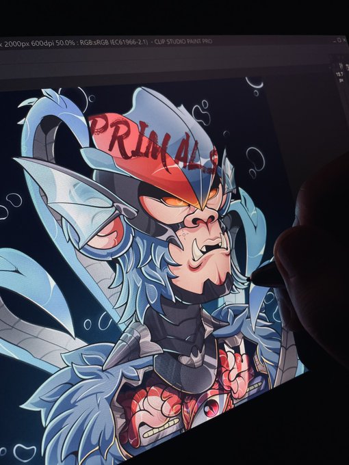 A digital artist works on a CLIP STUDIO PAINT PRO canvas displaying a fierce, blue-haired tribal character with glowing orange eyes, sharp fangs, and the bold red text "PRIMAL" across its forehead. The image directly supports the post, showcasing the "loading" artwork-in-progress being created for the @PrimalsNFTx art contest.