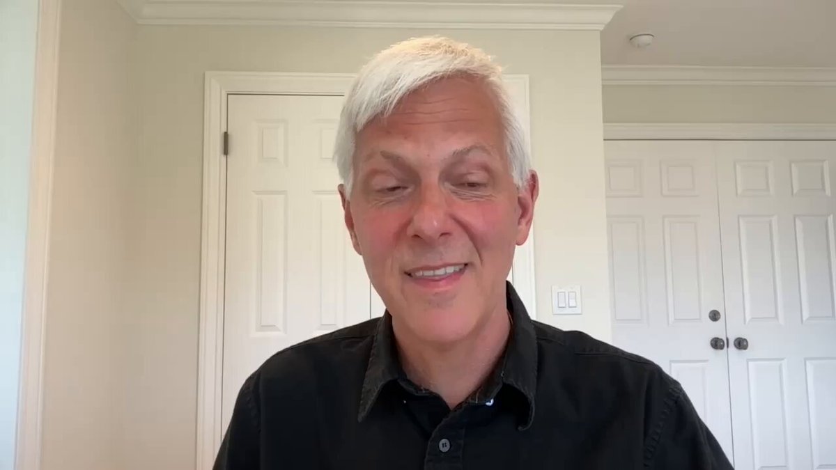 The image shows an older man wearing a black shirt, sitting at a desk with his eyes closed while looking into the camera. The background features white walls and doors, creating a simple yet elegant setting for the scene. The caption of the image reads "Magical thinking replaced adversarial thinking" which is related to Bitcoin in some way or another.