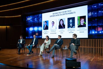 The Goldman Sachs Digital Assets Conference features a panel of speakers discussing "Beyond the 4-Year Cycle: Opportunities in Crypto Markets," as shown on the screen behind the seated panelists. This image visually represents the maturing crypto conversation highlighted in the accompanying post.