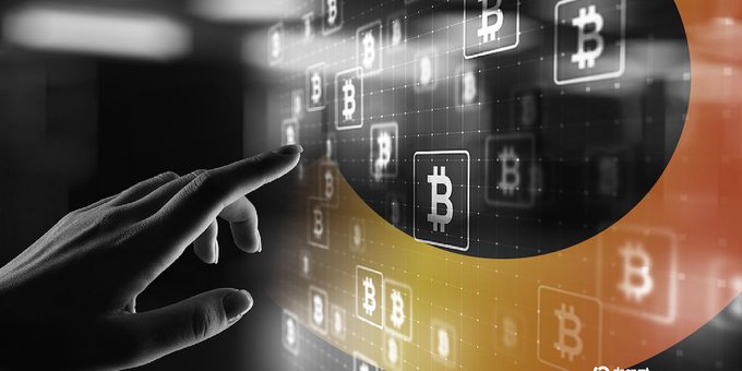 A hand reaches toward a digital display of Bitcoin logos arranged in a grid with orange highlights, symbolizing cryptocurrency and digital finance.