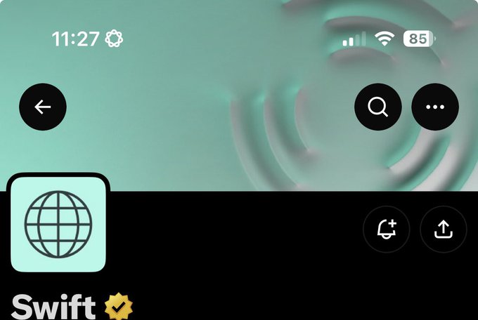 A close-up screenshot of what appears to be the SWIFT network app interface, displaying the time 11:27, 85% battery, and a teal/green background with a globe icon and the word "Swift" with a verification checkmark. The post humorously notes the ironic resemblance to Ripple's (XRP) branding, highlighting the visual similarity between SWIFT's interface and Ripple's corporate identity.