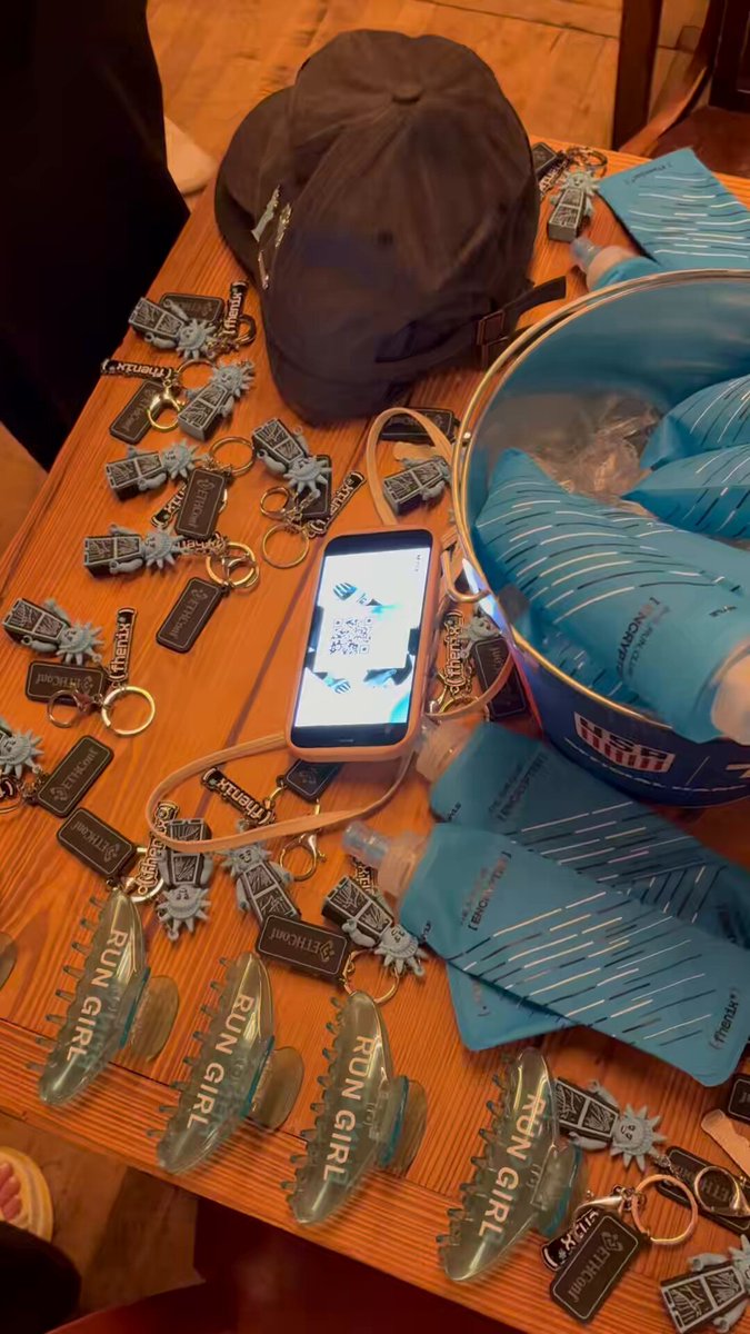 The image shows a wooden table covered with various items, including a cell phone, keys, and other accessories such as keychains and badges. The text "Kicking off the @MetaMask Builder Nights with @fhenix Stop by and grab some swag!" suggests that there is an event or gathering related to masks and masks-related merchandise.

The table appears to be a display of items for sale, possibly at a store or market. The presence of multiple keychains and badges indicates that the products are intended for personal use or as gifts. The cell phone on the table could serve as a promotional tool or a way to communicate with attendees about the event. Overall, the image conveys an atmosphere of excitement and anticipation surrounding the upcoming mask-related activities.