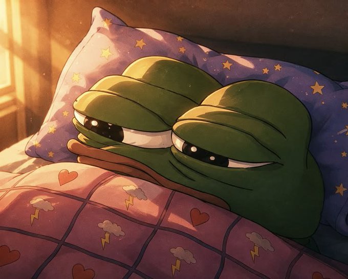 A cozy illustration of Pepe the Frog tucked under a pink blanket decorated with hearts and clouds, resting his head on a star-patterned pillow with sleepy eyes.