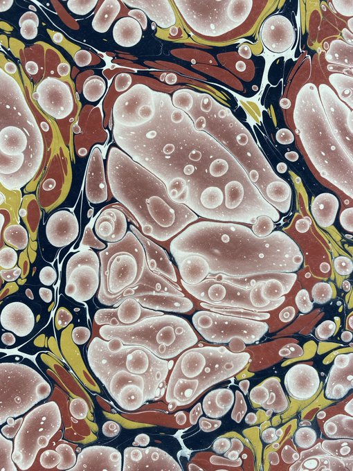 An abstract marbled art piece featuring swirling patterns in pink, white, yellow, brown, and dark blue with bubble-like circular forms.